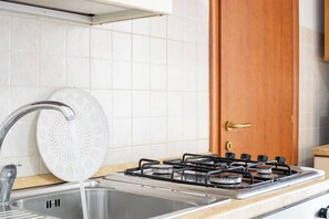 Eine Küche mit Gasherd, Spüle und einer dekorativen Spritzschutzwand.