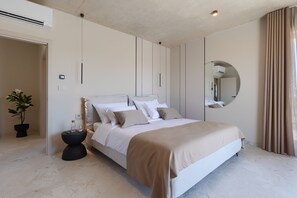 A bedroom with a bed, bedside tables, a potted plant, a mirror, and a door. - Villa Horizonte Verde (Istria - Motovun) (Motovun)