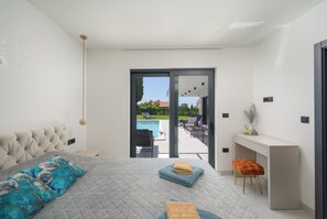 A bedroom with a bed, a desk, and a view of an outdoor pool area. - Villa Luna Kanfanar (Istria - Kanfanar) (Kanfanar)