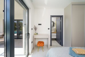 Un dormitorio moderno con cama, escritorio y baño.