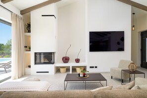 A modern living room with a fireplace, a flat-screen TV, a sofa, and a coffee table. - Villa Lunique (Istria - Rovinj) (Rovinj)