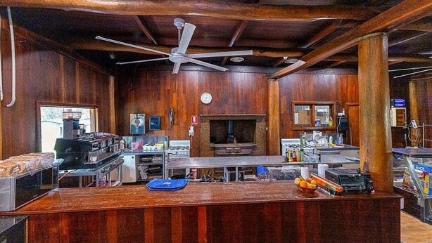 Una cocina con paredes de madera, un ventilador de techo y una estufa grande.