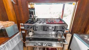 Una cocina compacta con cafetera, microondas y pileta.