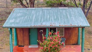 A small, single-story building with a green roof and wooden walls.