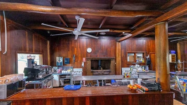 Una cocina con vigas de madera, un ventilador de techo y una isla grande.