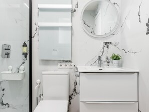 Un bagno moderno con WC, lavandino e specchio.