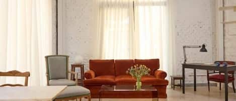A living room with a sofa, a coffee table, a chair, and a table.