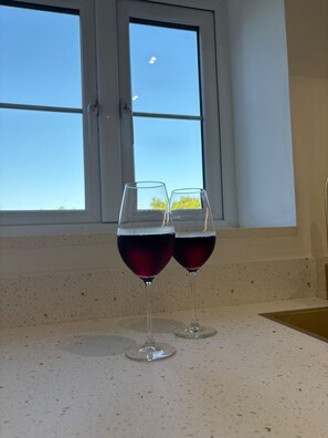 Two wine glasses on a countertop with a window in the background. - Lavish, The White Apartment (Bury St Edmunds)