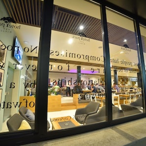 Un intérieur moderne avec des espaces aménagés pour s’asseoir et une partie réservée au restaurant, bien visible.