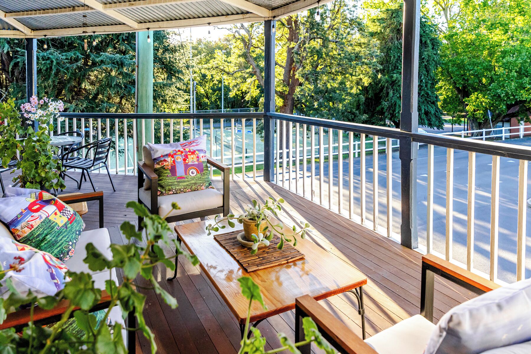 Un espace extérieur abrité, aménagé avec une table en bois, des chaises et un banc.