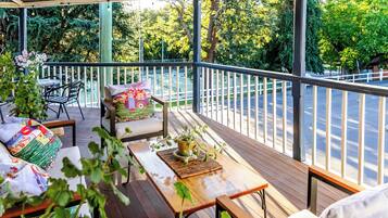 Un espace extérieur abrité, aménagé avec une table en bois, des chaises et un banc.