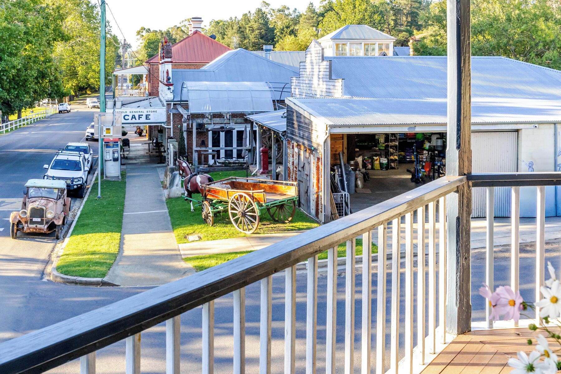 Une vue de rue avec un café, une épicerie et un immeuble doté d’un garage.