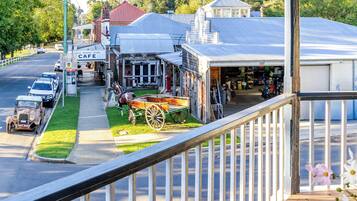 Une vue de rue avec un café, une épicerie et un immeuble doté d’un garage.