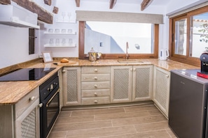 Una cocina equipada con horno empotrado, lavamanos y refrigerador.
