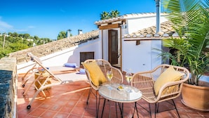 A patio with wicker furniture, a glass table, and a potted plant. - Hotel Restaurante Casa Del Maco (Benissa)