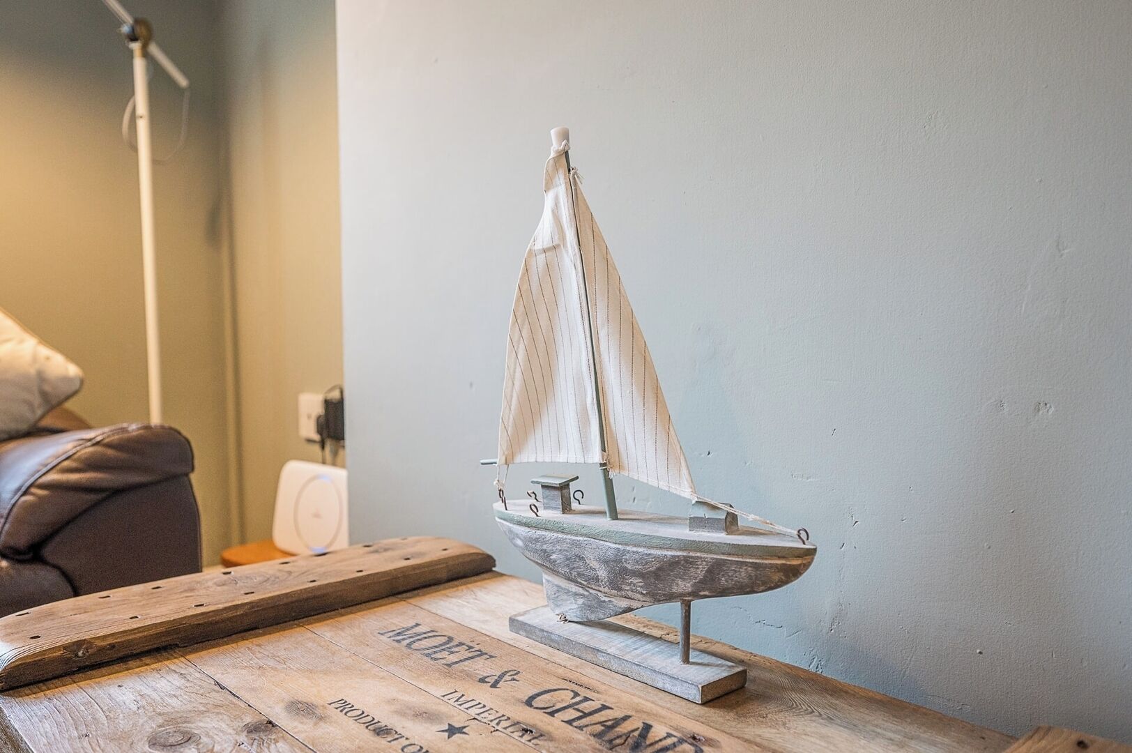 Un velero modelo sobre una superficie de madera con un letrero antiguo debajo.