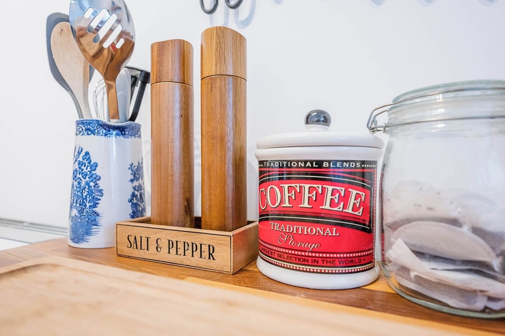 A kitchen counter with a salt & pepper set, a coffee canister, and a glass jar.