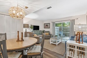 Ein modernes Wohnzimmer mit einem runden Holztisch, zwei Sofas, einem Couchtisch und einem Fernseher.