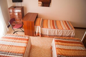 Una habitación con dos camas, un escritorio, una silla y una cómoda.