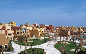 A resort with multiple buildings, a central pathway, and palm trees. - Grand Makadi (Makadi Bay)