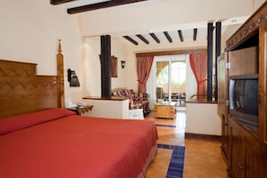 A room with a bed, a TV, a desk, and a view of the outside. - Grand Makadi (Makadi Bay)