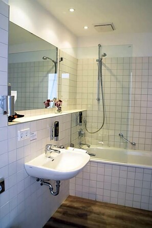 Un baño con lavabo, espejo, ducha y bañera.