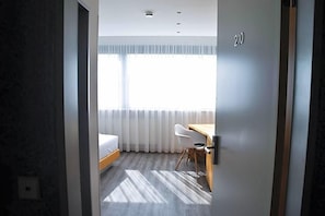 Una habitación de hotel moderna con cama, escritorio y silla.