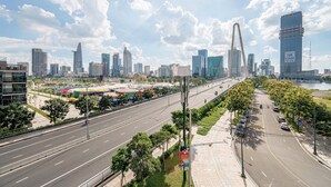 Un paisaje urbano con edificios modernos, un puente destacado y una carretera con varios carriles.