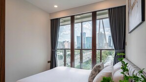 Una habitación de hotel con un ventanal grande, una cama y vistas a un paisaje urbano.