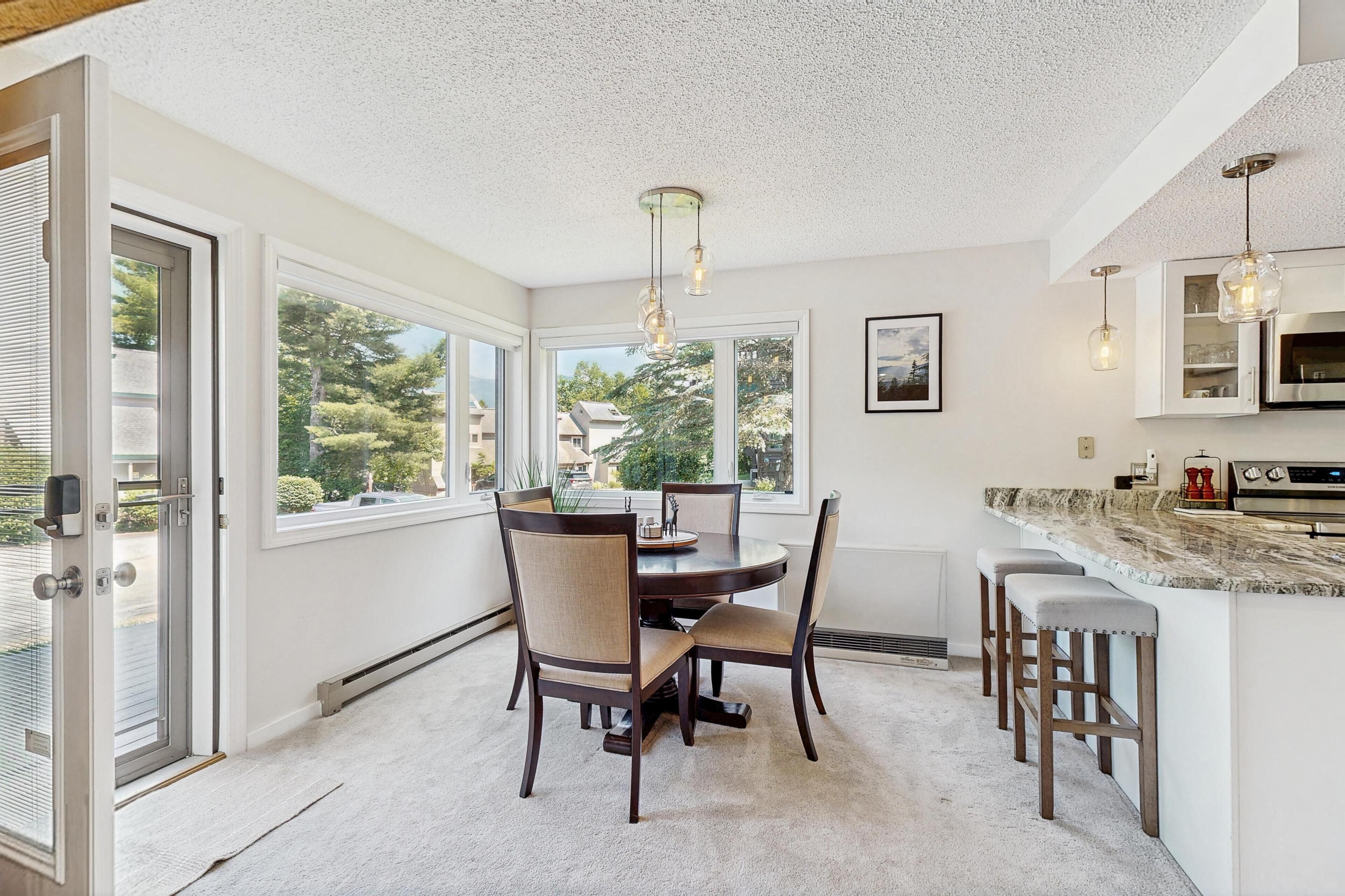 Una cocina moderna con comedor, ventanas amplias y vistas al exterior.
