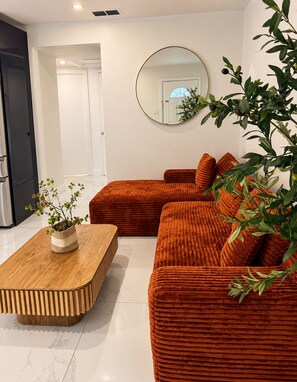 A modern living room with a sectional sofa, a wooden coffee table, and a potted plant. - Central House Stadium+Airport - Busch Gardens 3BR BBQ 7 PPL Tampa FL (Tampa)