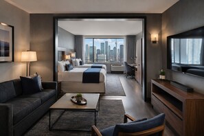 A modern hotel room with a city view, a sofa, a bed, a desk, and a television. - Modern Apartments (Toronto)