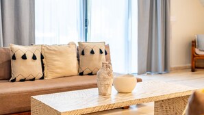 Ein Wohnzimmer mit einer Couch, Zierkissen, einem Couchtisch und einer Vase.