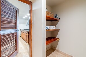 A hallway with a wooden door, a kitchen area with a sink, and a storage unit with shelves. - The Annex - Private Villa - Large Pool and Jacuzzi (San Pedro)