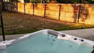 Un jacuzzi con una valla de madera al fondo.
