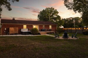 Una casa de ladrillo con terraza, mobiliario exterior y una parrilla.