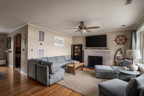 Una sala de estar con un sofá gris, una mesita de centro y una chimenea.