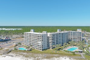 Ein mehrstöckiges Hotel mit Pool und Zugang zum Strand.