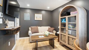 A living room with a sofa, coffee table, and wooden cabinet.