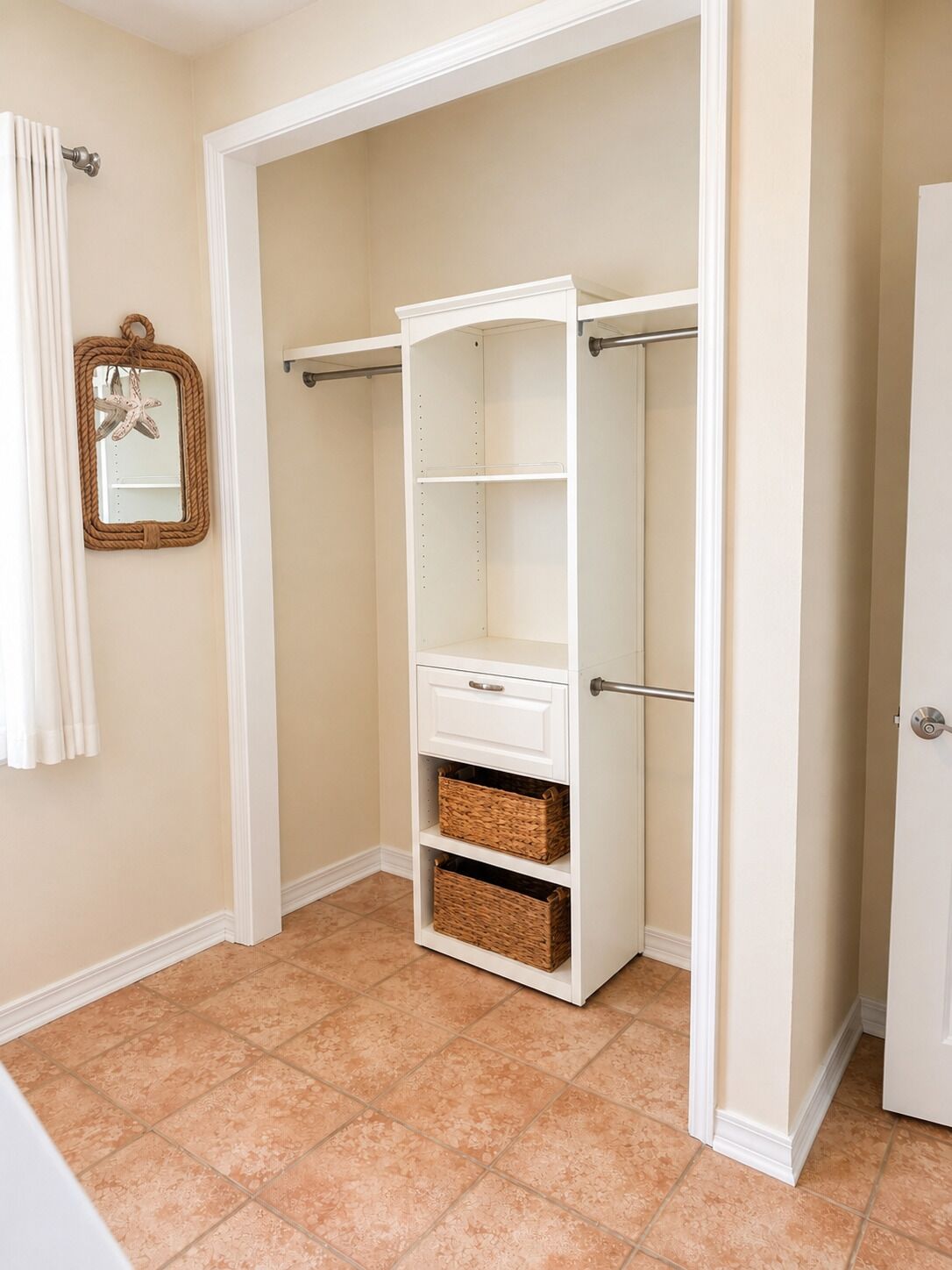 A walk-in closet with open doors, a mirror, and wicker baskets.