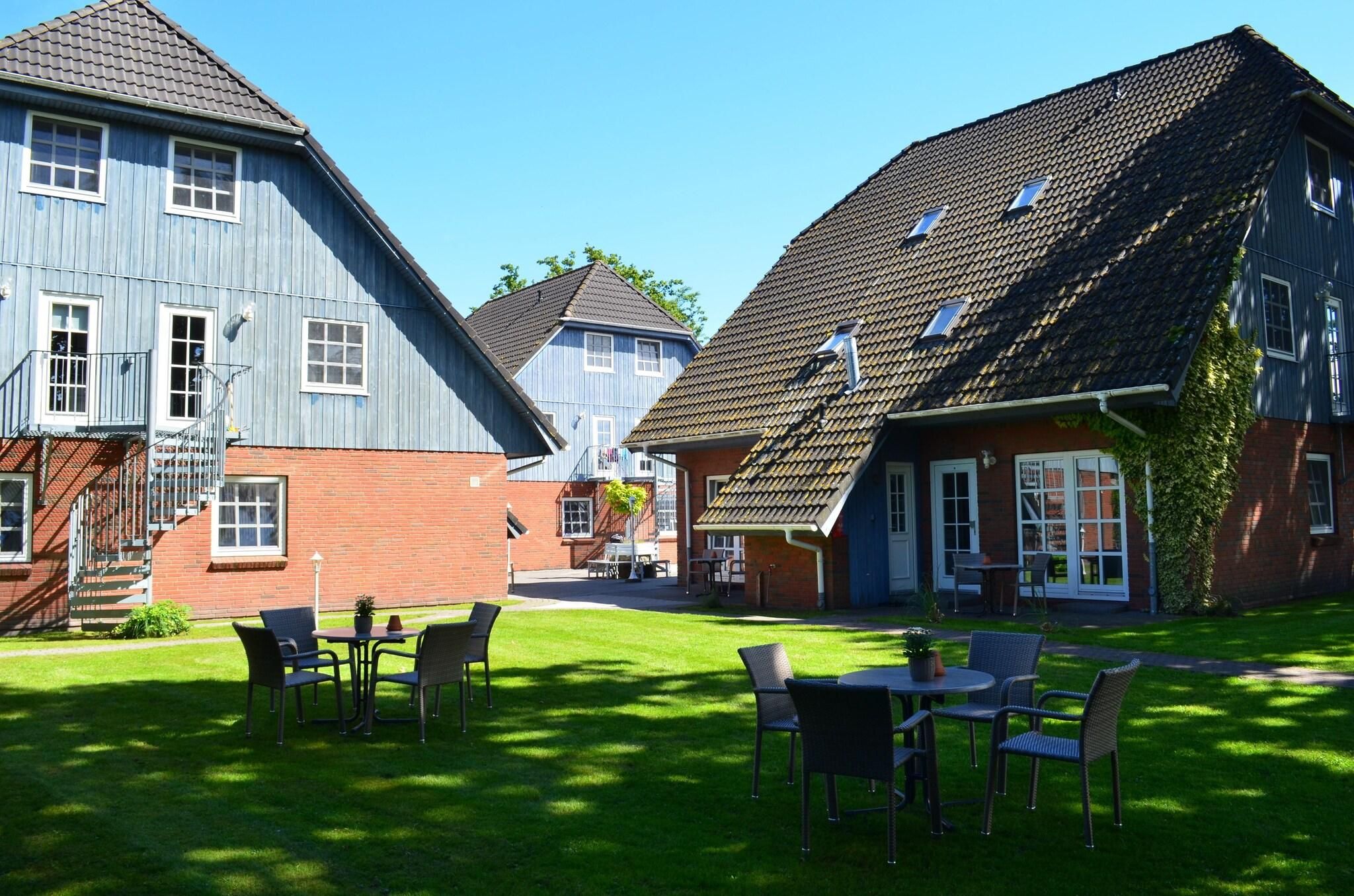Ein Innenhof mit Außenbestuhlung und einem Gebäude mit geneigtem Dach.
