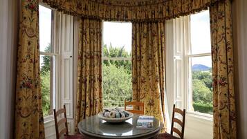 A dining area with a round table, chairs, and a bowl of decorative items.
