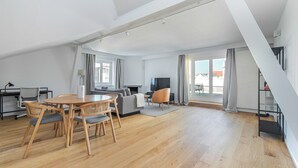 Ein modernes Wohnzimmer mit Essbereich, Kamin und großem Fenster.