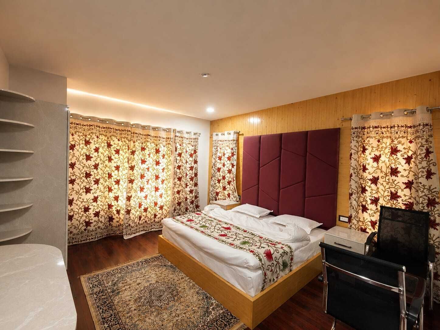 A bedroom with a bed, a headboard, a desk, and a chair.