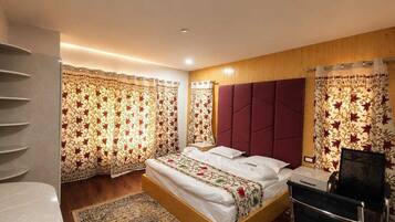 A bedroom with a bed, a headboard, a desk, and a chair.
