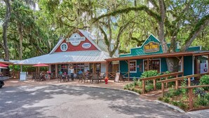 A rustic coffee shop with outdoor seating, a Hershey's ice cream sign, and a ranch-themed building with a green awning. - River Ranch Luxury Retreat | Cozy 1BR Cabin 303 (River Ranch)