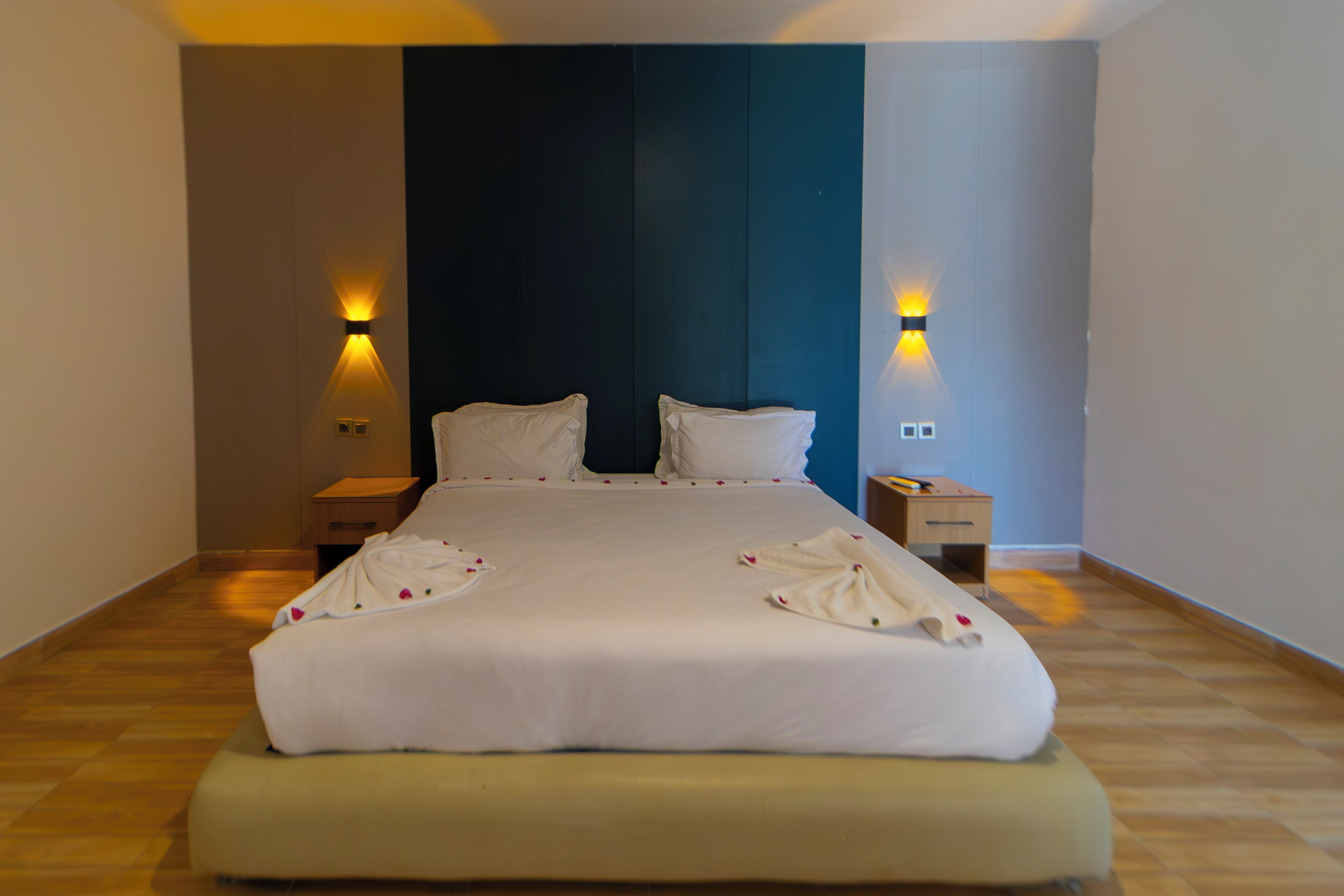 Ein Hotelzimmer mit einem großen Bett, zwei Nachttischen und Wandlampen.