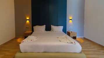 Ein Hotelzimmer mit einem großen Bett, zwei Nachttischen und Wandlampen.