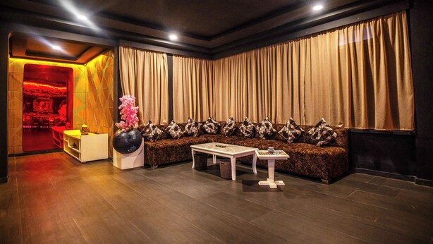 A room with a sofa, a small table, and a decorative vase. - rose garden resort marrakech (Marrakech)