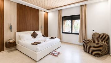 Un dormitorio moderno con una cama grande, una mesita de noche, una ventana con cortinas y una silla a rayas.